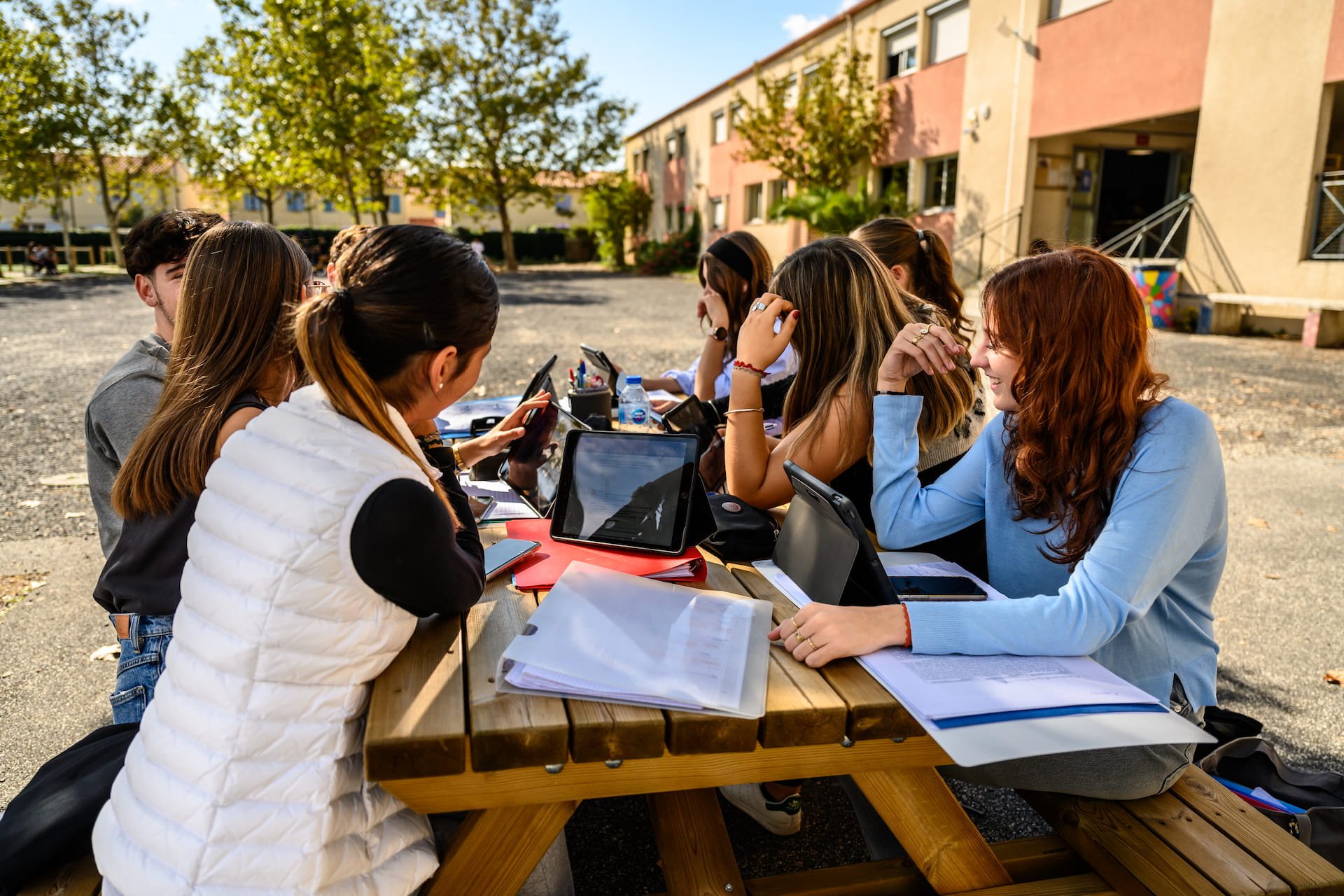 Collégiens assis dans des fauteuils, en train de lire un livre